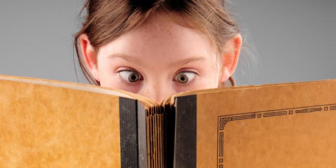 a cross-eyed child reading a book